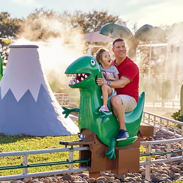 Vater mit Sohn auf Opi Mümmels Dino Abenteuer Fahrgeschäft
